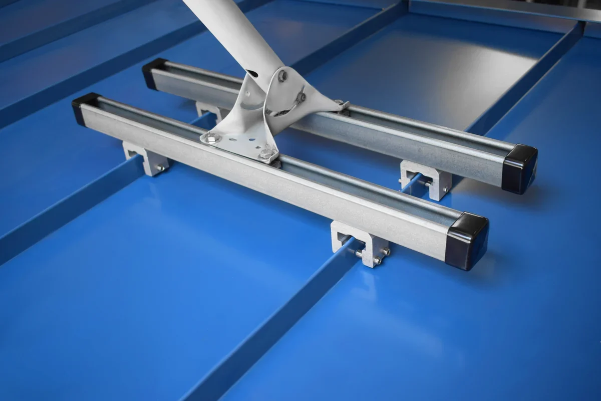 SataMount RCT installation mounted on a blue standing seam metal roof with two rails and a satellite mast bracket